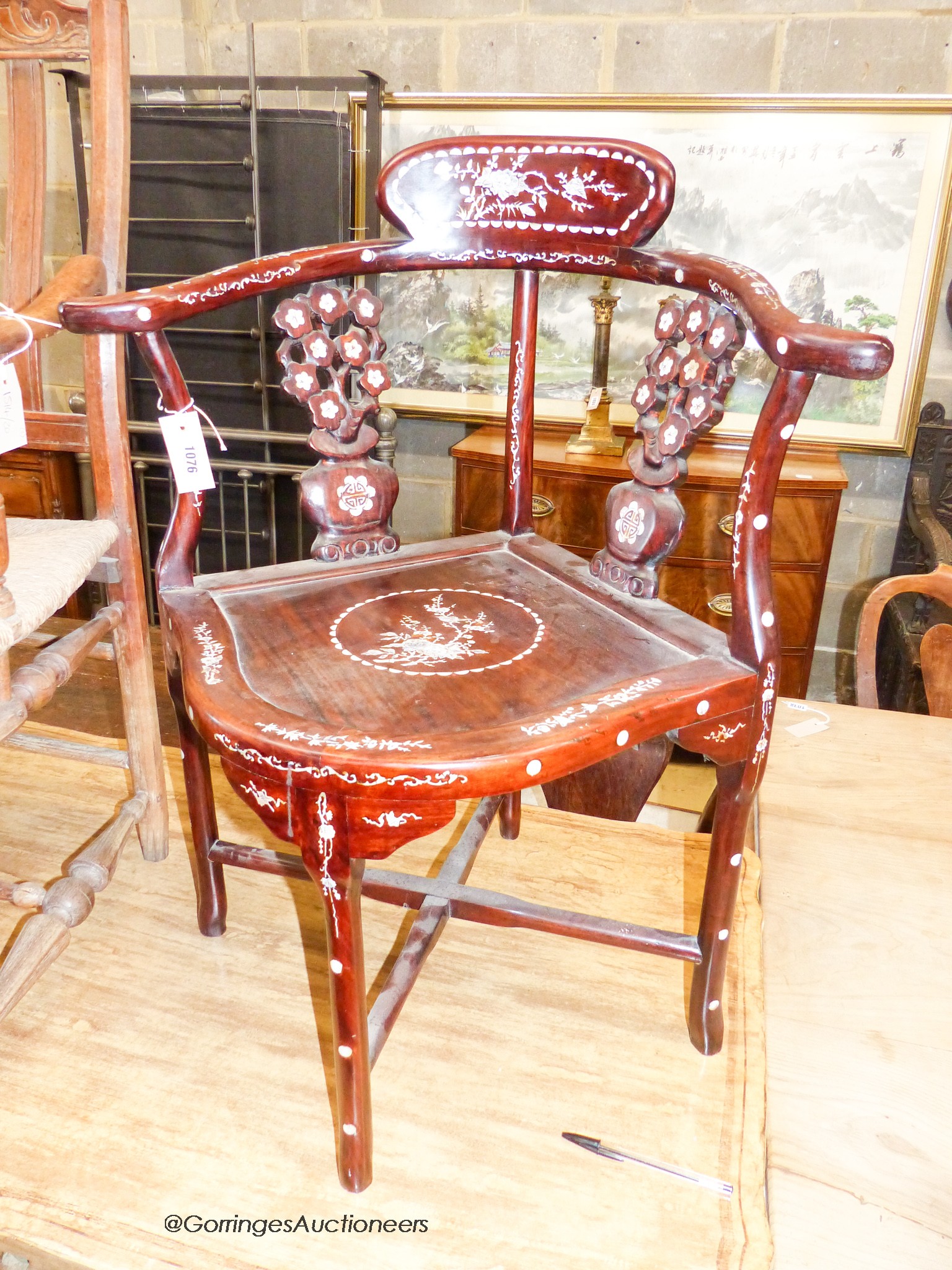 A 20th century Chinese mother of pearl inlaid hardwood corner elbow chair